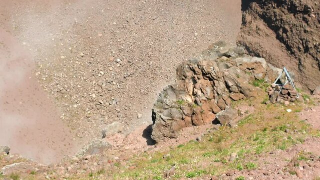 Close up shot of smoke coming out of the crater of Mount Vesuvius, which is a somma-stratovolcano located on the Gulf of Naples and Pompeii in Campania, Italy at daytime.