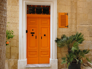 Fototapeta na wymiar Traditional vintage painted wooden door in Malta. Popular travel destination. Entrance to house. Exterior of typical houses on the Mediterranean island of Malta - April, 2022.