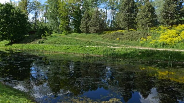 Springtime landscape with canal in Fort Bema park, city of Warsaw in Poland, panning to the right.