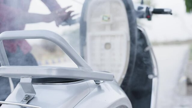 smoke coming out from dicky of electric scooter due to battery catched fire when rider opens the scooty seat - concept of battery failure or malfunction and safety