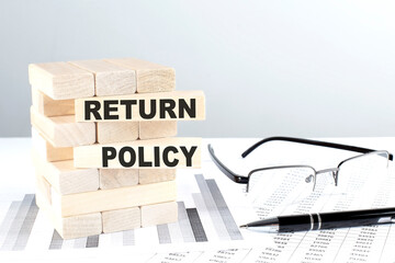 RETURN POLICY is written on wooden blocks on a chart background