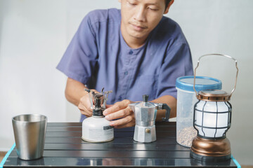 Asian boy learning to make coffee with moka pot.
