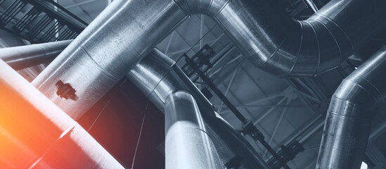 Industrial concept background blue toning. Steel pipelines, valves gas and oil refinery plant industry with sunlight