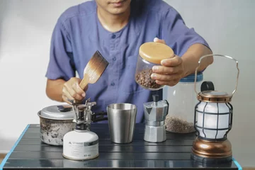Papier Peint photo Lavable Bar a café Garçon asiatique apprenant à faire du café avec un pot de moka.