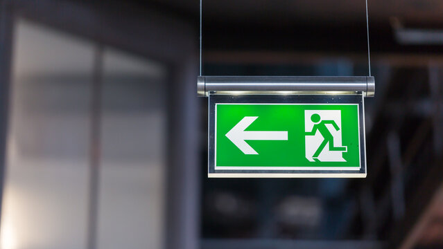 Illuminated emergency exit sign. Arrow pointing to the left.