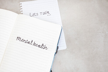 let’s talk mental health. Handwritten on notebook with grunge or rustic background and copy space 
