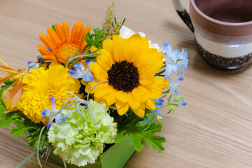 フラワーアレンジメントとマグカップ