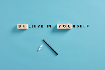 The motivational message believe in yourself with wooden cubes. Self confidence, courage, encouragement and personal trust - obrazy, fototapety, plakaty