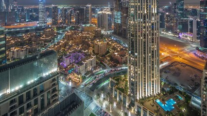 Aerial panoramic view of a big futuristic city with hotels night timelapse. Business bay and Downtown district with many skyscrapers and traditional houses, Dubai, United Arab Emirates skyline.