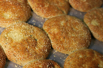 Breads on tray with cheese topping. Close-up on baking sheet in the oven.