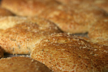 Breads on tray with cheese topping. Close-up on baking sheet in the oven.
