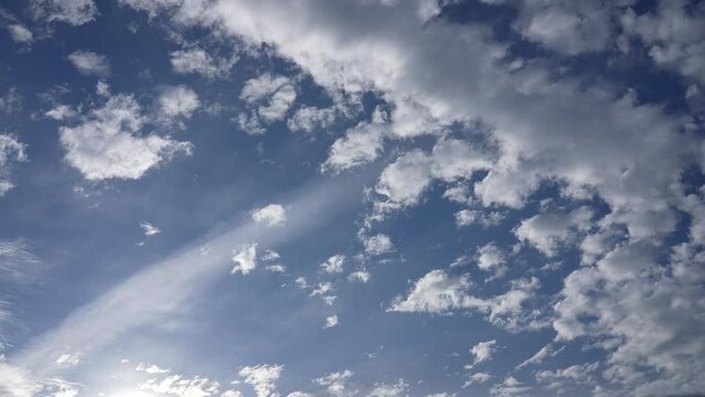 4k video time lapse of amazing cloudy sunny blue sky. Sunrays, white fluffy clouds flying high overhead isolated in clear blue sky background