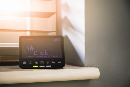 Smart meter placed on an interior window sill with sun light shinning through blinds
