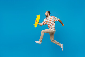 Full body young side view happy fun cool caucasian man 20s wear orange striped t-shirt hold yellow...