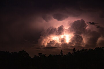 Fototapeta na wymiar Lightning in the sky during a storm at night