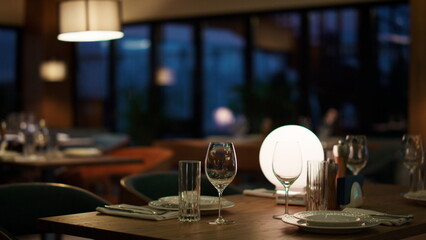 Modern hotel restaurant table in evening cafe. Woman waiting for romantic dinner