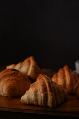 Fresh baked butter croissant on wooden cutting board ready to serve. Fresh croissants for breakfast. Close up view