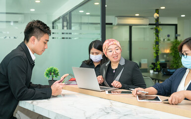 Group of Asian office business people working together in a modern co working space.