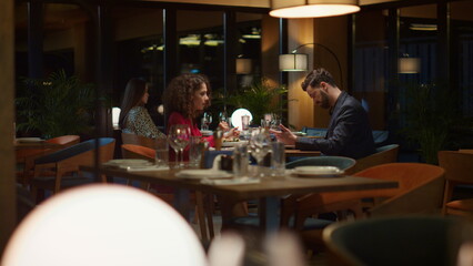 Mixed race couple eating enjoying restaurant food meal on night dinner date.