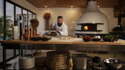 Chef cook preparing pizza in kitchen. Man taking food in restaurant stone oven. - obrazy, fototapety, plakaty