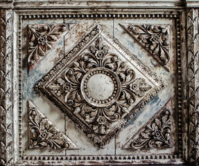 Carved wooden element in the Baroque style in gray-beige.