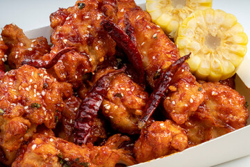 Fried chicken with spicy sauce  traditional Korean food, Fried chicken with sweetcorn and Kimchi pickle on wooden table.