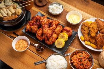 Fried chicken with spicy sauce  traditional Korean food, Fried chicken with sweetcorn and Kimchi pickle on wooden table.