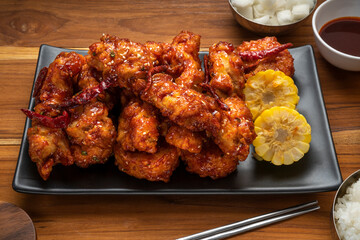 Korean fried chicken with spicy sauce  traditional Korean food, Fried chicken with sweetcorn and Kimchi pickle on wooden table.