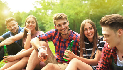 happy young friends enjoying picnic and eating
