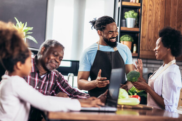 Happy multigenerational african american family make dinner together.