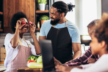 Happy multigenerational african american family make dinner together.