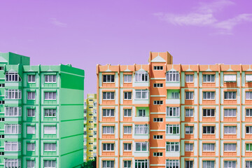 Green and orange panel building architecture houses on purple sky background. Nine-story old urban residential houses with windows