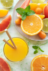 Fototapeta na wymiar Glass of juice and citrus fruits