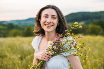 portrait of young happy female enjoying beautiful sunset in the field. Beautiful countryside. Slow living concept