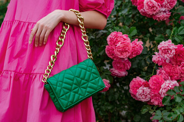 Trendy quilted faux leather green color bag, handbag with chunky chain  in stylish summer women's outfit. Fashion details. Copy, empty space for text

