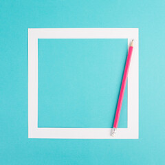 Pencils on a blue paper background, white frame with copy space for text, minimalism, creative and business concept, pastel colored 