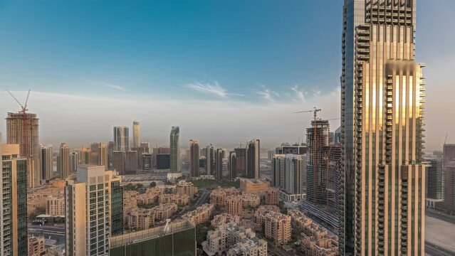 Panorama showing aerial panoramic skyline of a big futuristic city during sunset timelapse. Business bay and Downtown district with skyscrapers and traditional houses, Dubai, United Arab Emirates