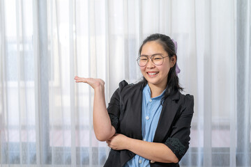 Asian happy woman opens hands palm up showing and holding empty or something with confidential on black copy space for production and information.