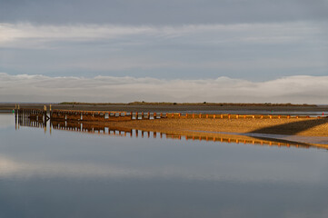A reflection of an old jetty in early evening light