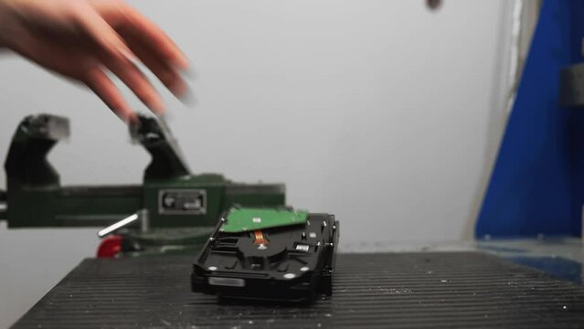 Man puts used hard disk drives on table in domestic workshop closeup. Pile of physical information storage units in studio