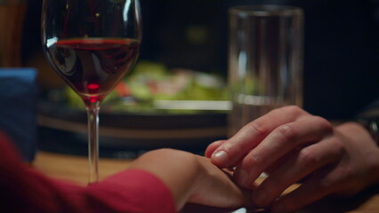 Love couple holding hands at romantic restaurant dinner date. Intimate concept.