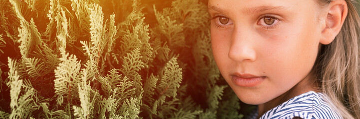 portrait face of candid offended upset little kid girl of eight years old with long blond hair on...
