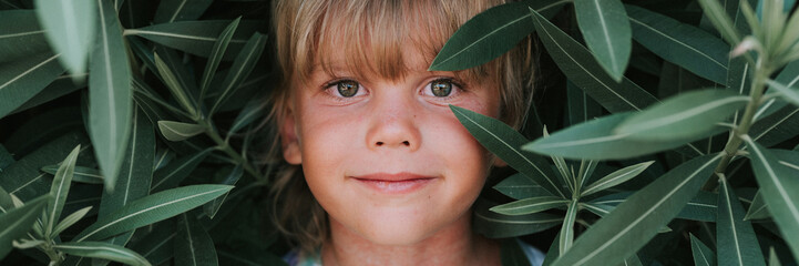 portrait face of candid happy little kid boy of five years old with problem allergic skin and long...