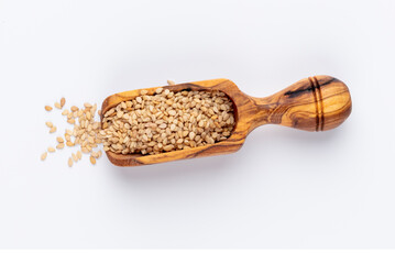 Bio natural sesame seeds on wooden bowl.