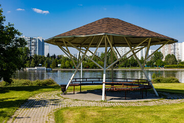 a gazebo with a tiled roof stands in the park