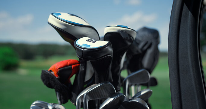 Professional sport golf clubs in bag outside. Putter equipment in golfing cart.
