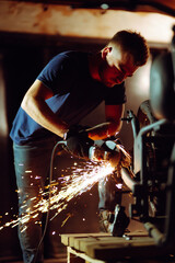 Motorcycle repair. Young man repairing motorbike in garage. Mechanic fixing motorcycle engine.