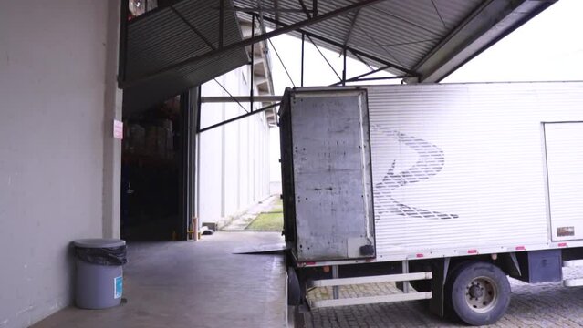 A man loading up a pallet on a docked truck