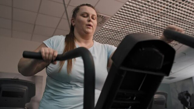 From down of overweight woman doing training at the gym. Shot with RED helium camera in 4K.  