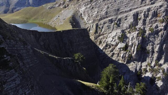 Aerial drone video from iconic and beautiful lake Drakolimni of Tymfi mountain which resides at high altitude above sea, Vikos National Park, Zagori, Greece